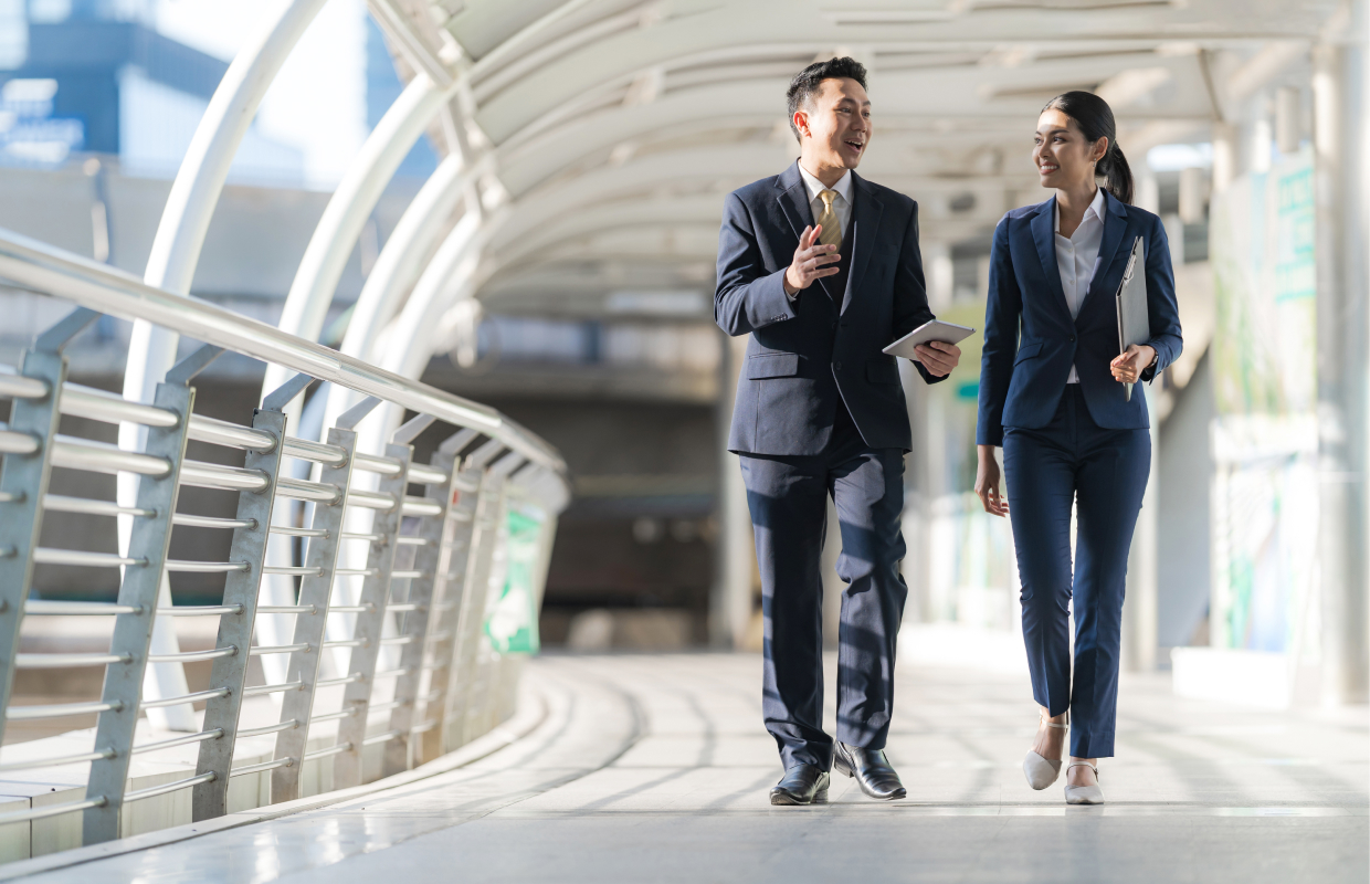 two business people walking side by side talking about business plans